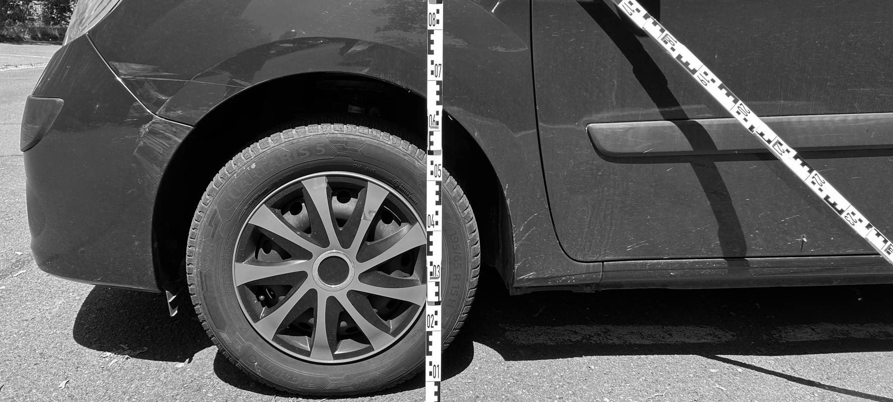 Oranger Fremdlack auf der dunklen Flanke eines Hyundai ix35, Beschädigung über beide Türen