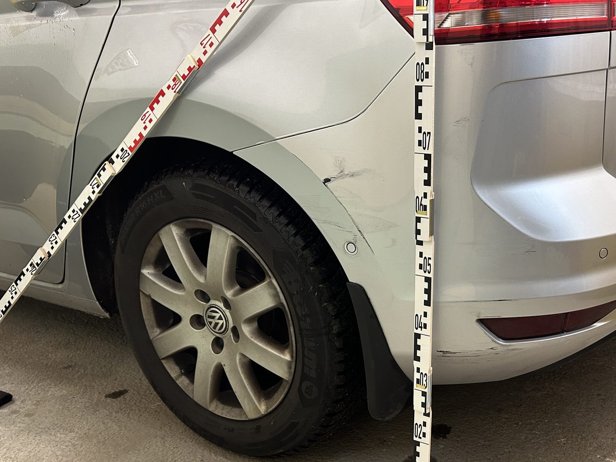 Aufnahme eines beschädigten Fahrzeugbereichs mit angelegtem Maßstab